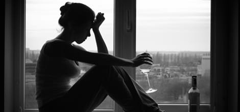 Woman drinking wine in window